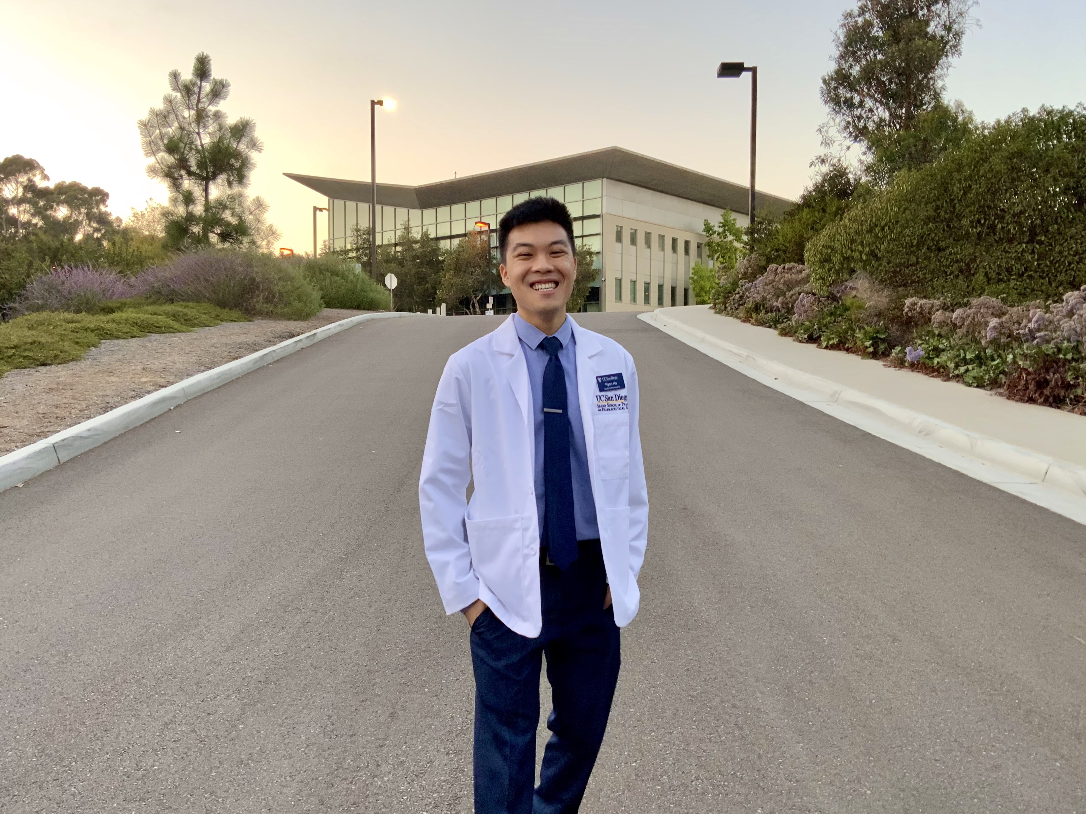Ryan Ha posing for a picture wearing a white coat.